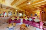 This stunning chalet boasts a spacious open-plan living area with exposed wooden beams, creating a warm and inviting atmosphere.