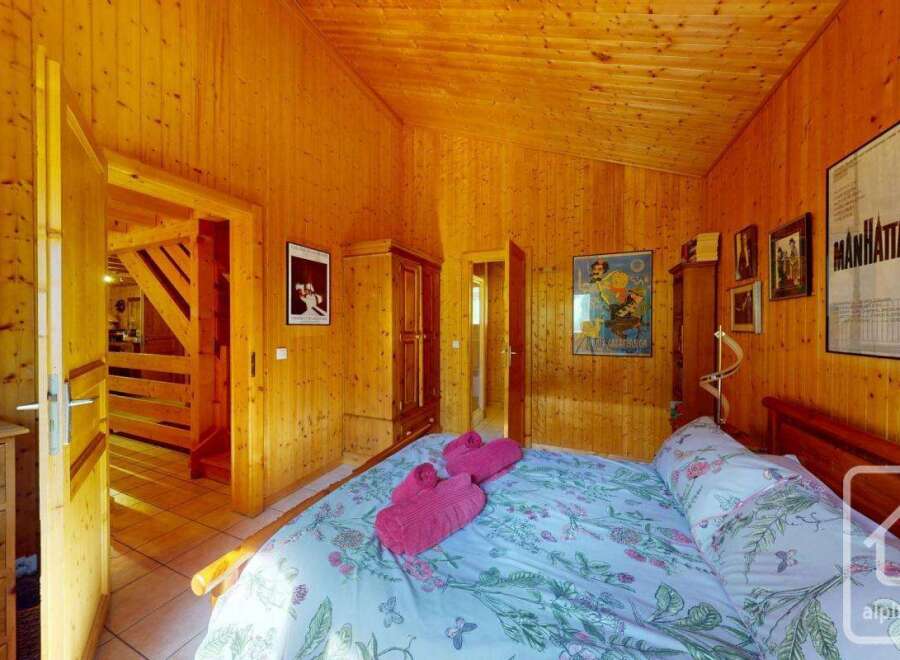 Cozy chalet bedroom with wooden walls and floral bedding.