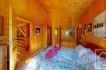 Cozy chalet bedroom with wooden walls and floral bedding.
