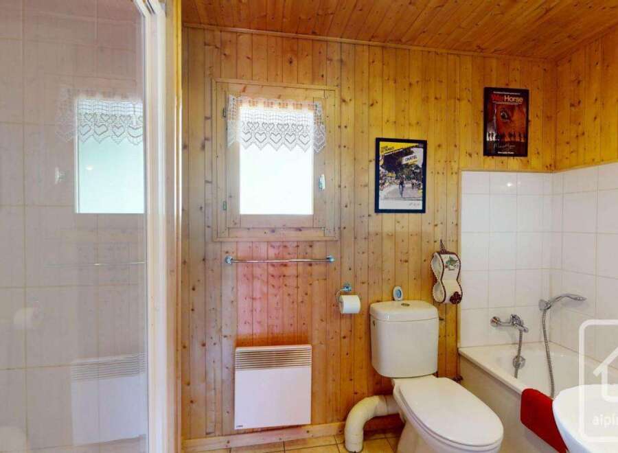 This charming bathroom boasts a delightful combination of rustic wood paneling and modern amenities.
