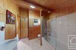 This charming bathroom boasts a combination of wood paneling and tiled walls, creating a warm and inviting atmosphere.