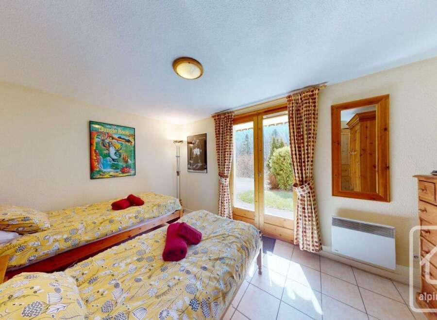 This charming bedroom features twin beds with cheerful yellow bedding, perfect for a relaxing stay.
