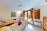 This charming bedroom features twin beds with cheerful yellow bedding, perfect for a relaxing stay.