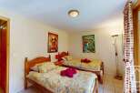 Cozy twin bedroom with bright yellow bedding, featuring two single beds and charming Disney-themed posters.