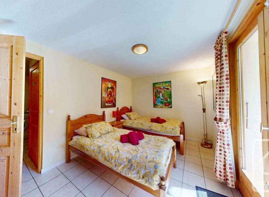 Cozy twin bedroom with wooden floors and charming decor.