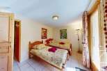 Cozy twin bedroom with wooden floors and charming decor.
