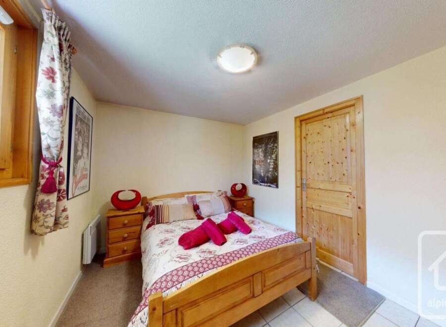 Cozy bedroom with wooden furniture and a floral bedspread.