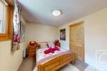 Cozy bedroom with wooden furniture and a floral bedspread.