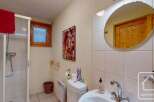 This charming bathroom boasts a walk-in shower, toilet, and sink, complete with a stylish mirror and ample storage.