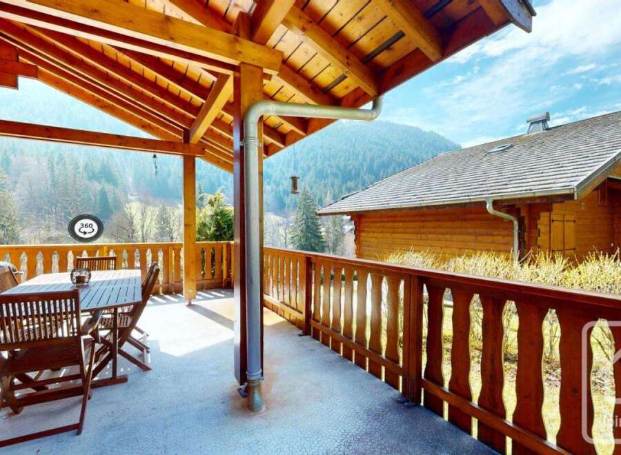 This stunning chalet boasts a spacious balcony with breathtaking mountain views, perfect for outdoor dining and relaxation.