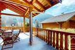 This stunning chalet boasts a spacious balcony with breathtaking mountain views, perfect for outdoor dining and relaxation.