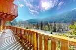 This stunning chalet boasts a spacious balcony with breathtaking mountain views.