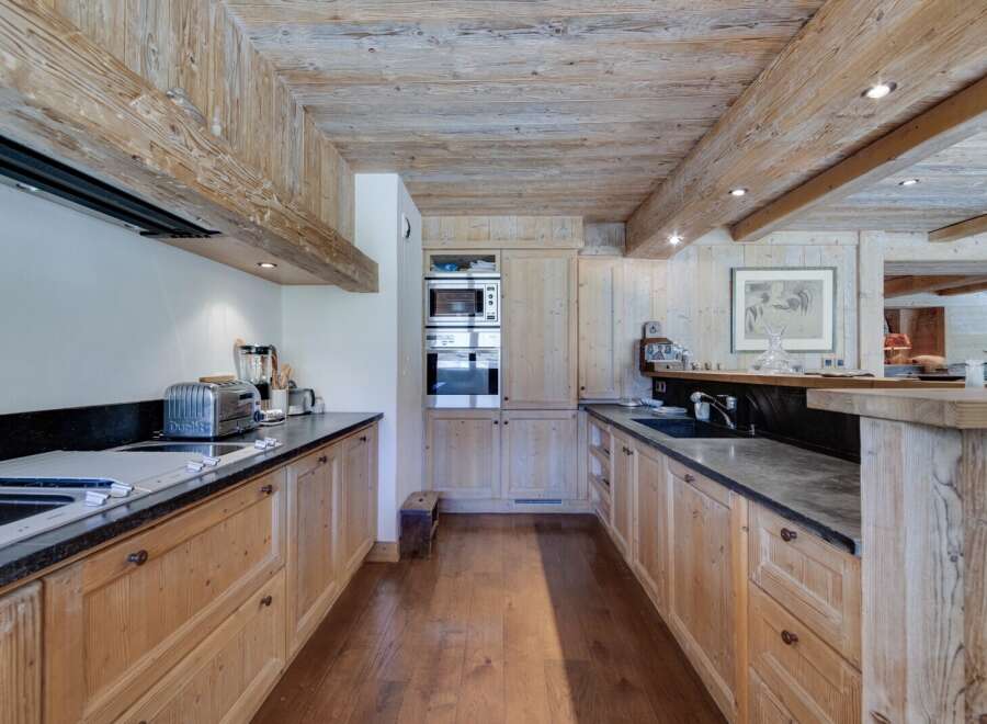 This stunning kitchen boasts a rustic-chic design with exposed wooden beams and a spacious layout.