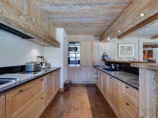 This stunning kitchen boasts a rustic-chic design with exposed wooden beams and a spacious layout.