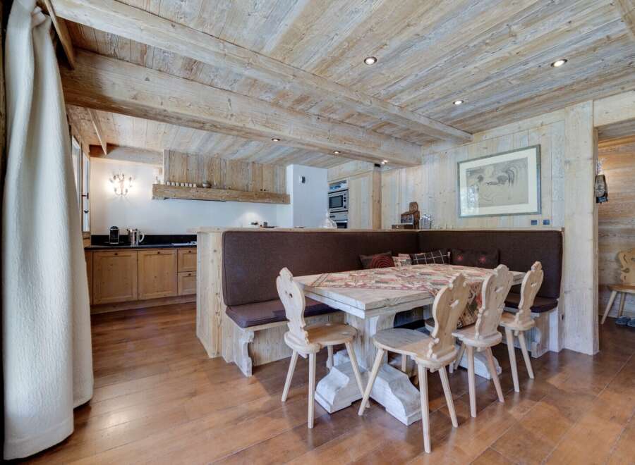 Rustic mountain chalet with exposed wood beams and a cozy dining area.