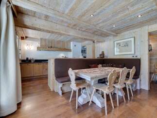 Rustic mountain chalet with exposed wood beams and a cozy dining area.