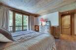 This charming bedroom boasts a rustic wooden ceiling and floors, creating a cozy and inviting atmosphere.