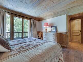 This charming bedroom boasts a rustic wooden ceiling and floors, creating a cozy and inviting atmosphere.