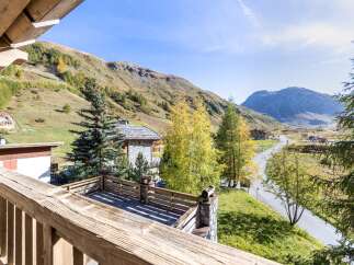 Mountain view balcony with wooden railings and stone details.