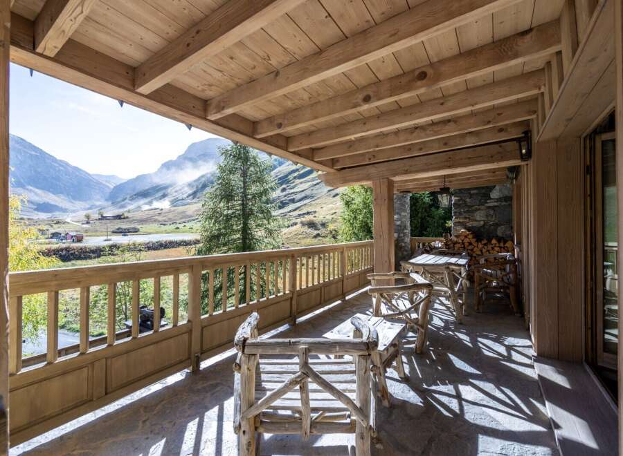 This stunning chalet boasts a spacious wooden deck with breathtaking mountain views.