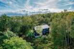 Nestled in a lush forest with mountain views, this secluded home offers a tranquil escape.
