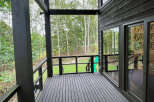 This home boasts a spacious deck overlooking a lush green landscape, perfect for outdoor relaxation and entertaining.