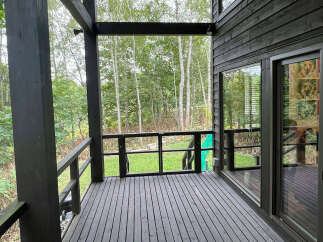 This home boasts a spacious deck overlooking a lush green landscape, perfect for outdoor relaxation and entertaining.