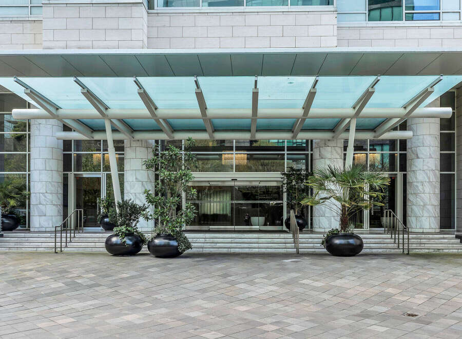 This stunning building boasts a grand entrance with a modern glass canopy, creating a welcoming and elegant atmosphere.