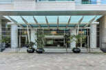 This stunning building boasts a grand entrance with a modern glass canopy, creating a welcoming and elegant atmosphere.