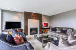 This luxurious living room boasts a stunning fireplace with a modern design, complemented by plush velvet sofas and armchairs.