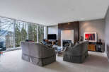 This luxurious living room boasts floor-to-ceiling windows offering breathtaking views, creating a bright and airy atmosphere.