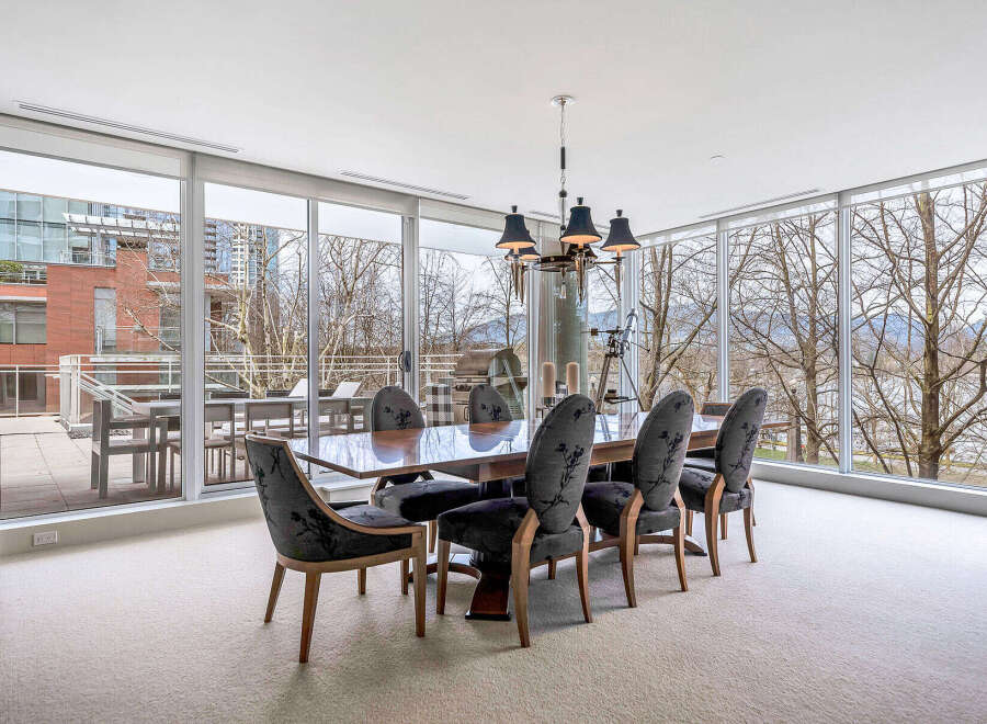 This luxurious dining room boasts floor-to-ceiling windows offering breathtaking views of the cityscape and natural landscape.