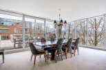 This luxurious dining room boasts floor-to-ceiling windows offering breathtaking views of the cityscape and natural landscape.