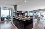 This luxurious condo boasts a stunning modern kitchen with high-end finishes, including granite countertops and sleek black cabinetry.