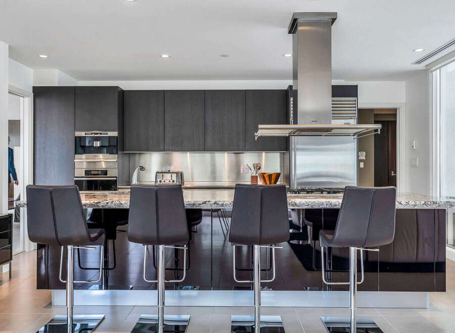 This stunning kitchen boasts sleek dark cabinetry, complemented by stainless steel appliances and granite countertops.