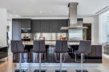 This stunning kitchen boasts sleek dark cabinetry, complemented by stainless steel appliances and granite countertops.