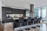 This stunning kitchen boasts sleek dark cabinetry, stainless steel appliances, and granite countertops.