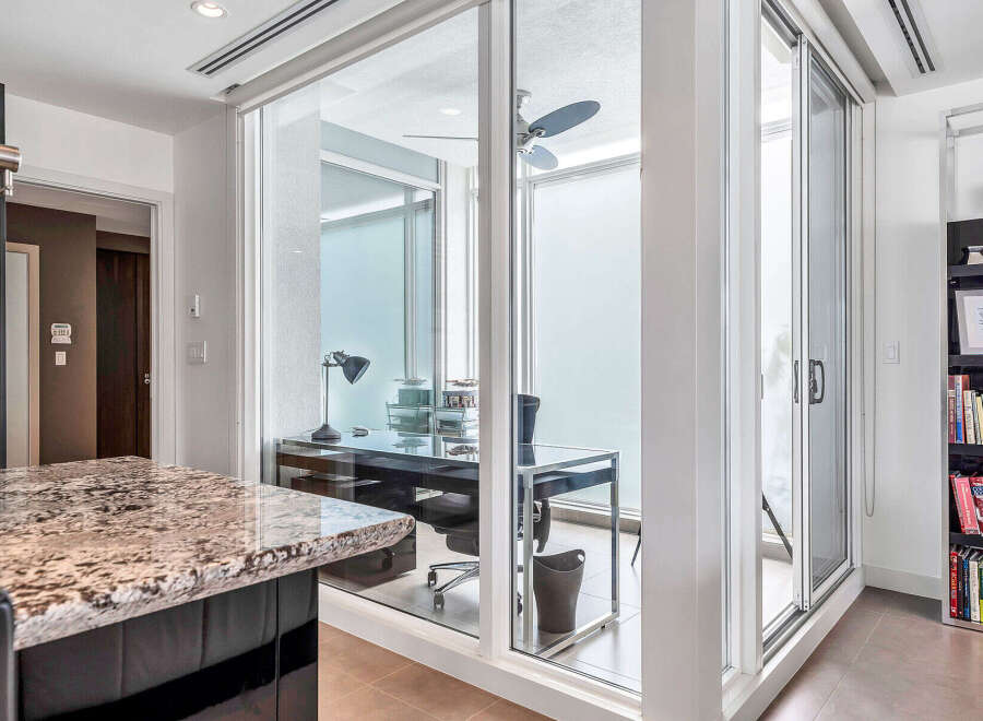 This stunning condo boasts a unique glass-enclosed office space, perfect for working from home while enjoying natural light.