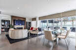 This luxurious condo boasts an open-concept living space with floor-to-ceiling windows offering stunning city views.