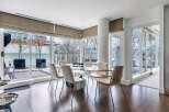 This luxurious condo boasts a spacious dining area with floor-to-ceiling windows offering breathtaking views.