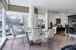 This luxurious condo boasts a spacious open-concept living area with floor-to-ceiling windows offering stunning views.