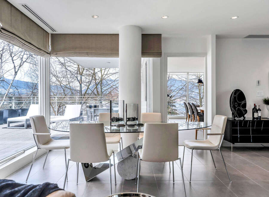 This luxurious condo boasts a spacious dining area with floor-to-ceiling windows offering breathtaking views.