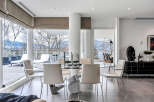This luxurious condo boasts a spacious dining area with floor-to-ceiling windows offering breathtaking views.