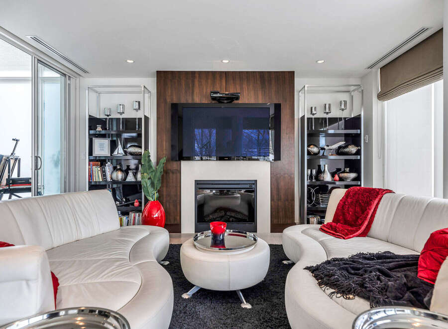 This luxurious living room boasts a stunning modern fireplace, complemented by a large flat-screen TV mounted above it.
