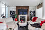 This luxurious living room boasts a stunning modern fireplace, complemented by a large flat-screen TV mounted above it.