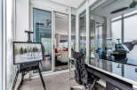 This stunning condo boasts a sun-drenched balcony office with floor-to-ceiling windows offering breathtaking views.