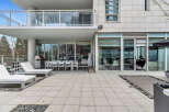 This luxurious condo boasts a spacious outdoor patio perfect for entertaining, complete with a built-in BBQ and comfortable lounge furniture.