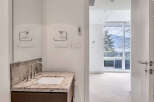 This modern bathroom boasts a sleek granite countertop vanity with a contemporary sink and faucet.