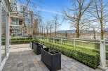 This stunning property boasts a private patio perfect for outdoor relaxation, complete with modern planters and a meticulously landscaped hedge offering both privacy and visual appeal.