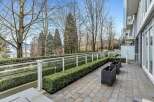 This stunning property boasts a private patio perfect for outdoor relaxation, complete with meticulously landscaped hedges and modern planters.